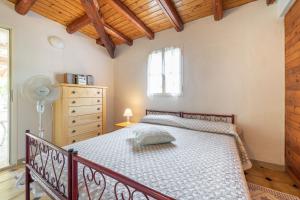 1 dormitorio con 1 cama, vestidor y ventana en Villa Balda, en Domus de Maria