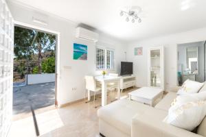 ein Wohnzimmer mit einem weißen Sofa und einem Tisch in der Unterkunft Villa Felicidad destino romántico in Sayalonga
