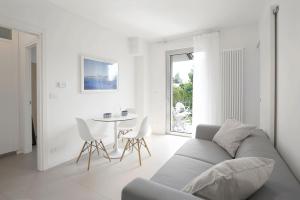 a white living room with a couch and a table at Baseventuno 4 Bilocale in San Martino della Battaglia