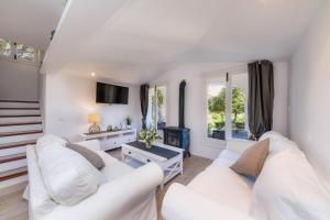 ein Wohnzimmer mit 2 weißen Sofas und einem Kamin in der Unterkunft Can Botana 1 in Cala de Sant Vicent