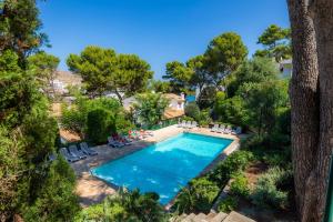 einen Blick über einen Pool mit Stühlen und Bäumen in der Unterkunft Can Botana 1 in Cala de Sant Vicent