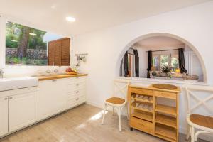 eine Küche mit weißen Schränken und einer Spüle und einem Fenster in der Unterkunft Can Botana 1 in Cala de Sant Vicent
