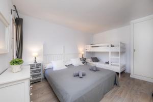 ein weißes Schlafzimmer mit einem großen Bett mit zwei Kissen in der Unterkunft Can Botana 1 in Cala de Sant Vicent + 21 Fotos