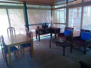 a living room with tables and chairs and a television at Casa Campo de tiro Morro Negro in Tuineje