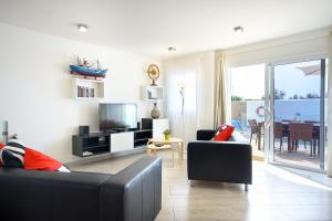 sala de estar con sofá y TV en Villa Xana, en Playa Blanca