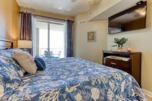 ein Schlafzimmer mit einem Bett mit blauer Bettdecke und einem Fenster in der Unterkunft Grand Panama Beach Resort #T1-1402 in Panama City Beach + 33 Fotos