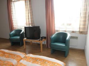 a living room with two chairs and a television at Ehila in Karlovy Vary