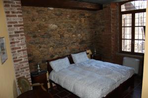 a bedroom with a bed in a brick wall at Il Baco Da Seta in Manta