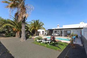 ein Haus mit einem Pool und Palmen in der Unterkunft Villa Mariola in Playa Blanca