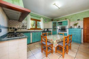eine Küche mit blauen Schränken sowie einem Tisch und Stühlen in der Unterkunft Los tres soles in Portocolom