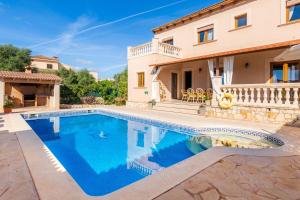 eine Villa mit einem Swimmingpool vor einem Haus in der Unterkunft Los tres soles in Portocolom