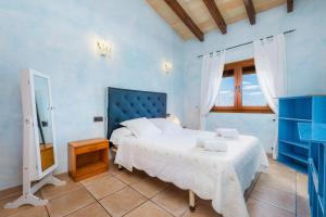 ein blaues Schlafzimmer mit einem Bett und einem Fenster in der Unterkunft Los tres soles in Portocolom + 23 Fotos
