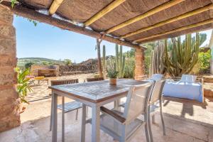 une table et des chaises sur une terrasse avec un cactus dans l'établissement Es Rafal Roig - Es Nou, à Sant Llorenç des Cardassar
