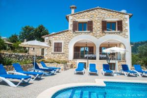 a villa with a pool and chairs and a house at Villa Rote in Campanet