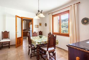 a dining room with a table and chairs and a window at Villa Rote in Campanet
