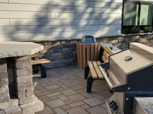 een patio met 2 banken en een barbecue bij Cobblestone Inn & Suites - Clarion in Clarion