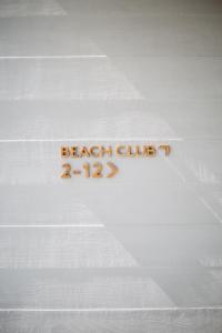 a sign that says beach club on a white wall at The Surfrider Malibu in Malibu