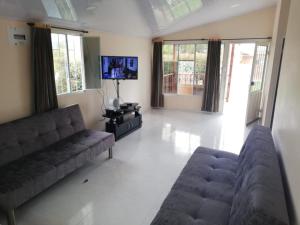 sala de estar con 2 sofás y TV de pantalla plana en Casa Campestre en Duitama en Duitama