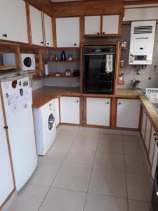 a kitchen with white appliances and wooden cabinets at LA CASA DEL MONO in Ushuaia