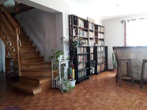a living room with a staircase and book shelves at LA CASA DEL MONO in Ushuaia