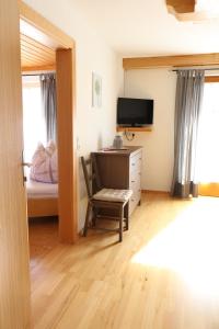 a bedroom with a desk and a bed and a television at Haus Pöckl in Strobl