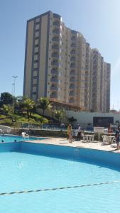 a swimming pool with a large building in the background at Golden Dolphin Express in Caldas Novas