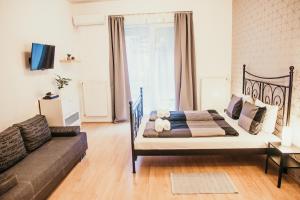 a bedroom with a bed and a couch at Elite Rooms & Apartments in Budapest