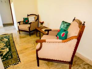 ein Wohnzimmer mit 2 Stühlen und einem Tisch in der Unterkunft Casa Perpetua Hotel D Charm in Manaus