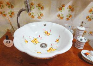 a bathroom sink with flowers painted on it on a table at Casa Perpetua Hotel D Charm in Manaus