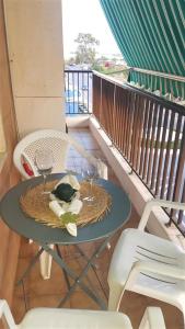 a table with two wine glasses on a balcony at Charming beachfront apartment/ Encantador apartamento frente al mar in Puerto de Sagunto