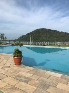 a large swimming pool with a mountain in the background at Toca do Caranguejo-Iate Clube Rio Verde - Ilha Comprida in Cananéia