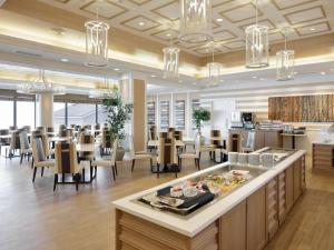 a dining room with tables and chairs and chandeliers at Yumihari-no-Oka Hotel in Sasebo