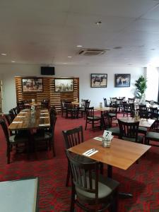 uma sala de jantar com mesas e cadeiras num restaurante em Pit Pony Hotel em Collinsville