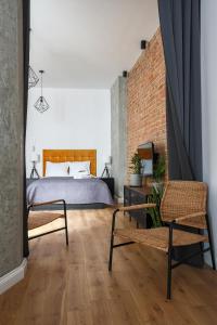 a bedroom with a bed and two chairs at Soft Loft 2 Apartment in Toruń