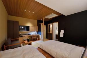 a hotel room with two beds and a kitchen at THE CHELSEA BREATH in Takamatsu