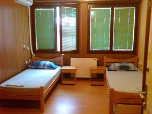 a room with two beds and two windows at Hostel AV Palanka in Bačka Palanka