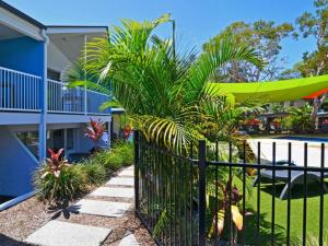 a fence in front of a house with plants at Nobby Beach Holiday Village in Gold Coast