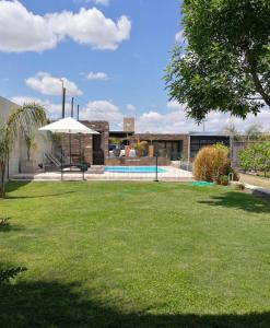 un patio con piscina y sombrilla en Loft & Wines en Maipú