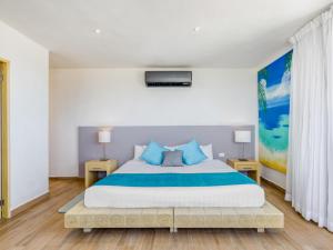 a bedroom with a large bed with blue pillows at Hotel Ojo De Agua in Puerto Morelos