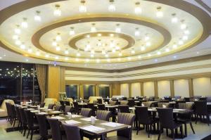 a dining room with tables and chairs and a large ceiling at Cheng Wan Grand Hotel in Puli