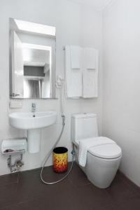 a bathroom with a toilet and a sink and a mirror at KL Serviced Residences Managed by HII in Manila