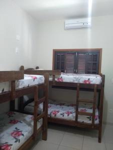 a room with three bunk beds in a room at Harmoni Hostel & Pousada in Abraão
