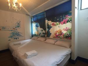 Greece Mediterranean B&B في تايتشونغ: سرير في غرفة مع لوحة على الحائط