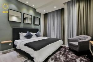 a bedroom with a large bed and a chair at Expressionz Suites by V&C in Kuala Lumpur