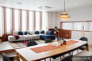 a living room with a couch and a table and chairs at Jstyle STAY Furano in Furano