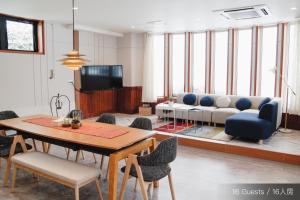 una sala de estar con una mesa y un sofá en Jstyle STAY Furano, en Furano