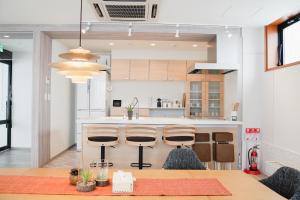 a kitchen with a table and some stools at Jstyle STAY Furano in Furano +37 photos