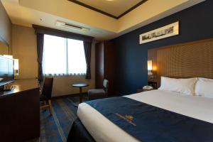 a hotel room with a bed and a television at Hotel Monterey Grasmere Osaka in Osaka