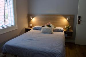 1 dormitorio con 1 cama grande y cabecero de madera en Carnarvon Lodge Kirribilli, Sydney en Sídney