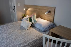 a bedroom with a bed with a wooden headboard and pillows at Carnarvon Lodge Kirribilli, Sydney in Sydney